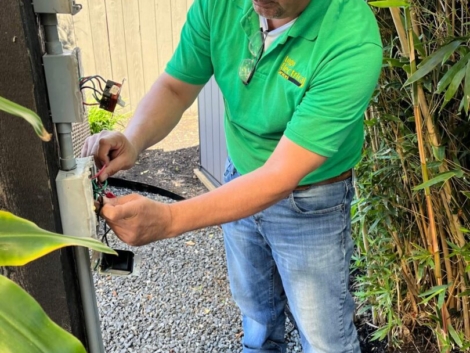 Electrician working on outdoor electrical box.