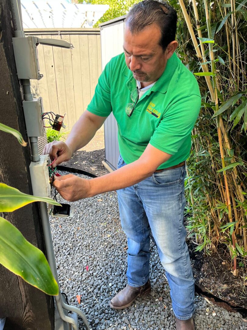 Electrician working on outdoor electrical box.