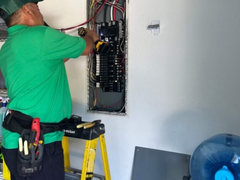 Electrician working on electrical panel.