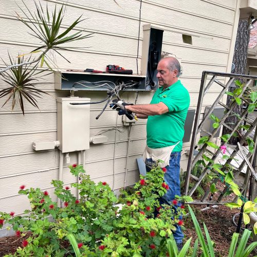 Electrician working on electrical box outdoors.