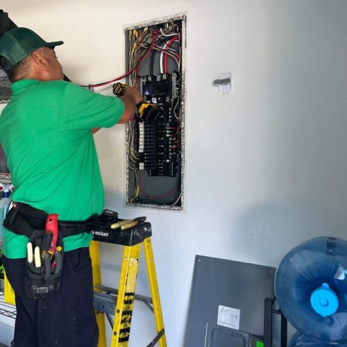 Electrician working on electrical panel.